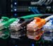 Conectores RJ45 transparentes de diferentes tipos de cables Ethernet en colores verde, negro, naranja y azul.